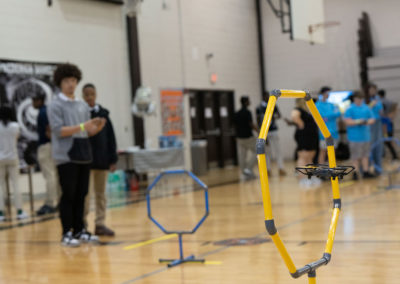 Students flying a drone through one of the hoops