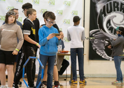 A student maneuvering a drone with his phone screen